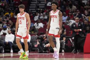 Houston Rockets guard Reed Sheppard (15) and forward Amen Thompson (1) walk up the court during the second half on a preseason NBA basketball game on Tuesday, Oct. 15, 2024 in Houston.