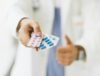 doctor-sujetando-pastillas-mano_23-2147822598